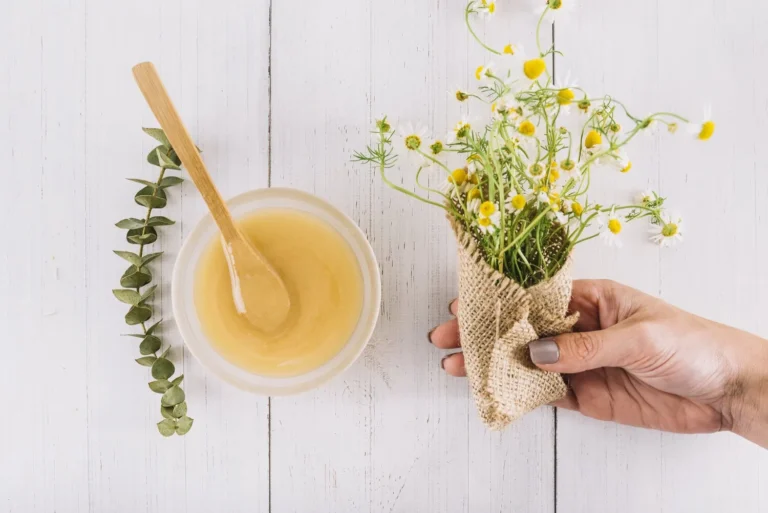 woman-s-hand-holding-bunch-chamomile-flowers-near-bowl-lemon-curd